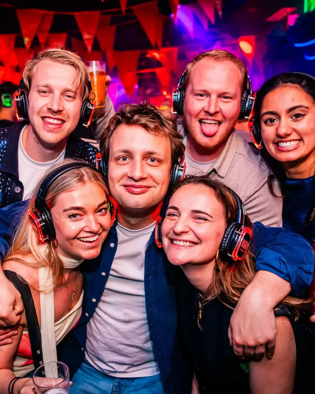 Vriendengroep met blauwe koptelefoons lacht samen